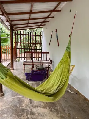 a green hammock in a room with a table at Casa Boutique Rincon in San Onofre