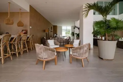 a room with chairs and a table and a bar at Edificio Playa dormida 2 con Piscina y playa in Santa Marta