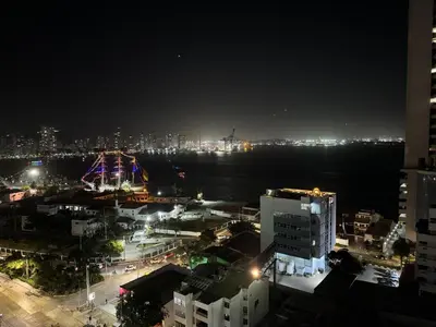 a city at night with a ferris wheel in the distance at Portofino Cartagena Bocagrande 604 ICDI in Cartagena de Indias