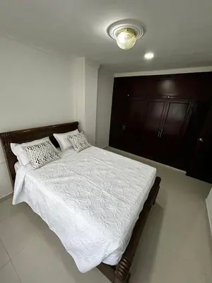 a bedroom with a bed with white sheets and pillows at Antares Apartment in Cartagena de Indias