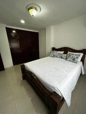a bedroom with a large bed with white sheets and pillows at Antares Apartment in Cartagena de Indias