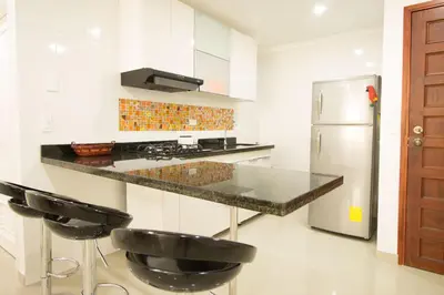 a kitchen with a counter and a refrigerator at Caribbean Summer - Livin Colombia in Cartagena de Indias