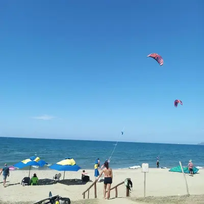 a group of people on the beach flying kites at Hotel Juanmar in Juan de Acosta