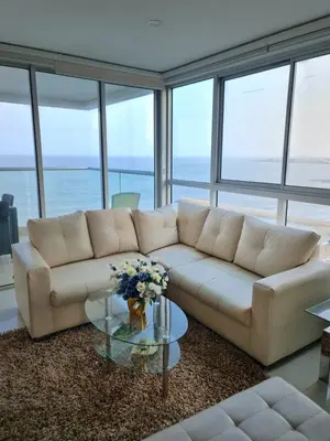 a living room with a white couch and a glass table at Beachfront Luxurious Apartment, Palmetto Beach in Cartagena de Indias