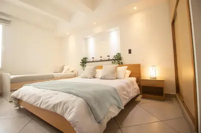 a bedroom with a large bed and a couch at Riviera Sunrise Beach - Frente al mar y vista panorámica a toda la ciudad in Cartagena de Indias