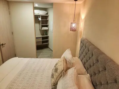 a bedroom with a bed with pillows and a closet at Dominique luxury 1410 Jacuzzi Privado in Cartagena de Indias