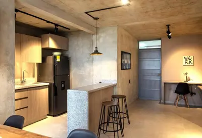 a kitchen with a bar with stools and a refrigerator at Encantador apartamento de diseño con hermosas vistas en Ciudad Mallorquín in Puerto Colombia