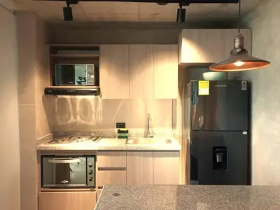 a kitchen with a black refrigerator and a sink at Encantador apartamento de diseño con hermosas vistas en Ciudad Mallorquín in Puerto Colombia