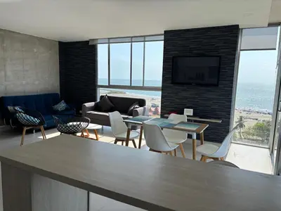a living room with a couch and a table and chairs at Cartagena SUNNO BEACH in Cartagena de Indias