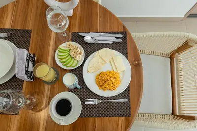a wooden table with a plate of eggs and bread at Casa Mishka Hotel Boutique Habitación #104 Nuevo Cartagena in Cartagena de Indias