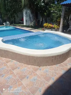 a large pool with a brick wall around it at Cabaña campestre Villa Liliana in Juan de Acosta