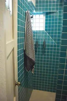 a blue tiled shower with a striped towel in a bathroom at Loft con terraza y jacuzzi en el centro historico in Cartagena de Indias
