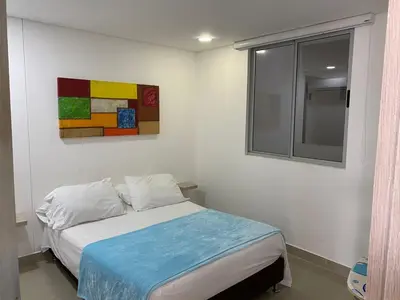 a bedroom with a bed and a painting on the wall at Apartamento 414 en Ocean Drive - Crespo Cerca al Mar in Cartagena de Indias