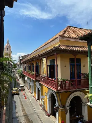 an old building with balconies and a street with a car at Casa Estrella Colonial Mansion in Cartagena de Indias