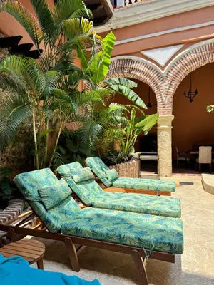 a couch sitting in a courtyard with plants at Casa Estrella Colonial Mansion in Cartagena de Indias