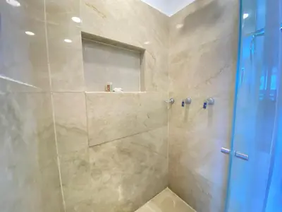 a bathroom with a shower with a blue door at Hermoso Aparta Suite en Crespo a 5 minutos caminando del aeropuerto primera línea Mar in Cartagena de Indias
