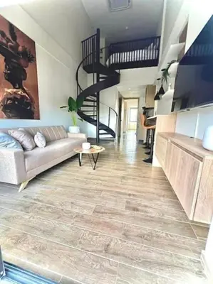 a living room with a couch and a spiral staircase at Appartement neuf centre Cartagena la matuna in Cartagena de Indias