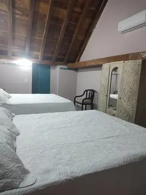 a bedroom with two beds and a chair at Portalon de Magallanes apto para familias in Cartagena de Indias
