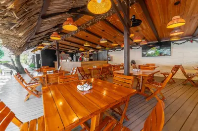 an empty restaurant with wooden tables and chairs at Pao Pao Cartagena in Isla Grande