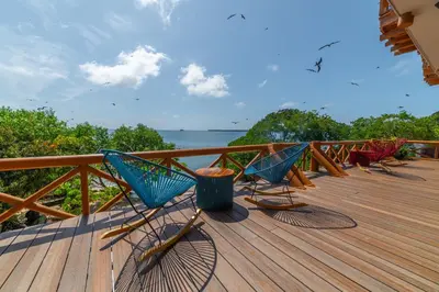 a row of chairs sitting on top of a wooden deck at Pao Pao Cartagena in Isla Grande