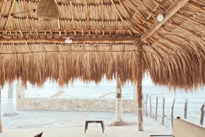 a straw hut on the beach with the ocean at Cabaña 5 Playa Piso 1- Palmar De Los Vientos-San Bernardo del Viento in Pueblo Coco