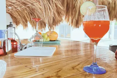a drink in a glass sitting on a wooden table at Cabaña 5 Playa Piso 1- Palmar De Los Vientos-San Bernardo del Viento in Pueblo Coco