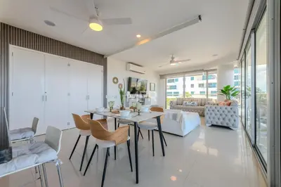 a dining room and living room with a table and chairs at Morros Epic Beachfront Apartment in Cartagena de Indias