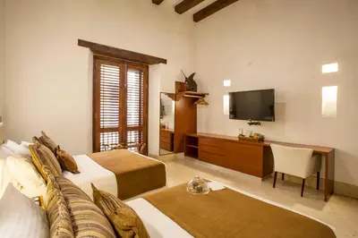a hotel room with two beds and a television at Casa Gastelbondo in Cartagena de Indias
