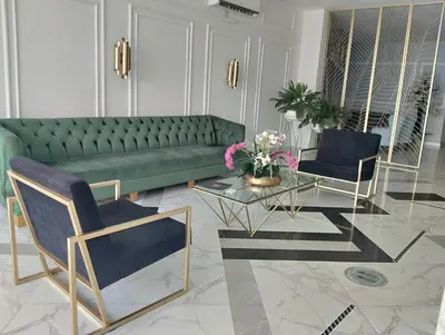 a living room with a green couch and two chairs at Hotel OR Suite in Barranquilla
