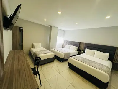 a hotel room with two beds and a television at Hotel OR Suite in Barranquilla