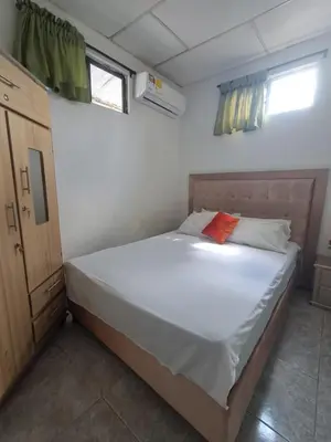 a bedroom with a white bed with an orange pillow on it at LE REEVE, 3BR, Paz, Diseño Bohemio & Grupos in Cartagena de Indias