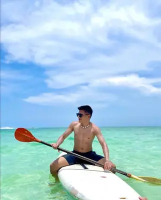 a man sitting on a paddle board in the ocean at Roma apartamento in Playa Blanca