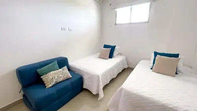 a room with two beds and a blue couch at Magico Apartamento Frente al Mar 4 Habitaciones BM63 in Coveñas