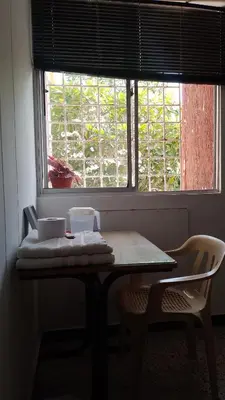 a table with two chairs in front of a window at Confortable habitación en apartamento familiar en el Prado in Barranquilla