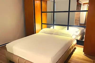 a bed in a room with a large window at Apartaestudios Calle 76 in Barranquilla