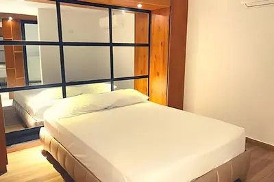 a bedroom with two beds and a large window at Apartaestudios Calle 76 in Barranquilla
