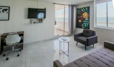 a living room with a couch and a desk and chairs at Stylish & Renovated Condo in El Laguito, Cartagena in Cartagena de Indias