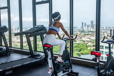 a woman riding an exercise bike in a gym at Muranocentro1601 in Cartagena de Indias