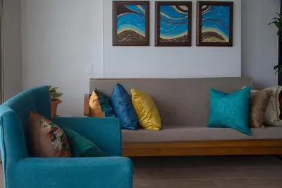 a living room with a couch and two blue chairs at Muranocentro1601 in Cartagena de Indias