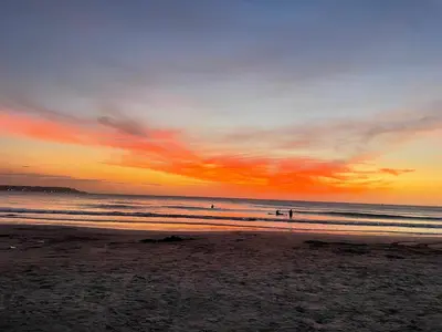 people walking on the beach at sunset at Hermoso Apartamento cerca a la playa in Cartagena de Indias