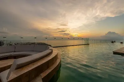 a swimming pool on top of a building with the sunset at Awesome View Historic Center, Castle and Sea 2BR in Cartagena de Indias