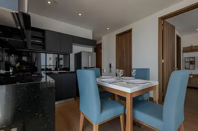 a kitchen with a dining table and blue chairs at New Apt Beautiful Sea View and Walled City 2BR in Cartagena de Indias