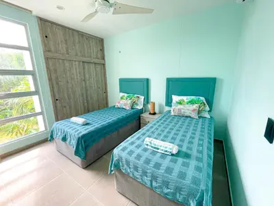 two beds in a room with blue walls and a window at Magico Apartamento Frente al Mar 3 Habitaciones TR22 in Coveñas