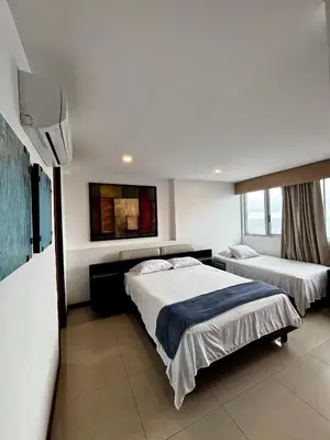 a hotel room with two beds and a tv at Paraíso en Bocagrande con Vista al Mar in Cartagena de Indias