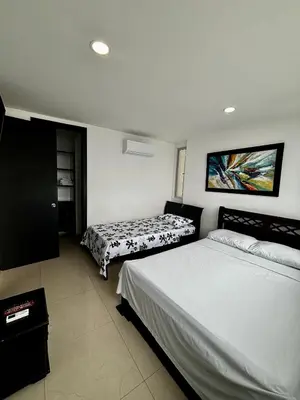 a bedroom with two beds and a painting on the wall at Paraíso en Bocagrande con Vista al Mar in Cartagena de Indias
