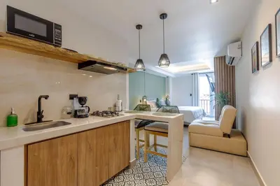 a kitchen with a sink and a living room at De la cruz Studio Apartments in Cartagena de Indias
