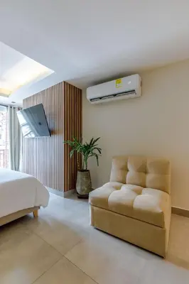 a bedroom with a bed and a couch and a fan at De la cruz Studio Apartments in Cartagena de Indias