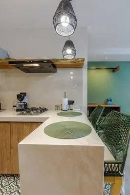 a kitchen with a table with two green chairs at De la cruz Studio Apartments in Cartagena de Indias