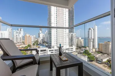 a balcony with a table and chairs and a view of the city at Bocagrande Loft - Livin Colombia in Cartagena de Indias