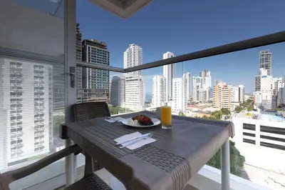 a table with a plate of food on a balcony at Bocagrande Loft - Livin Colombia in Cartagena de Indias